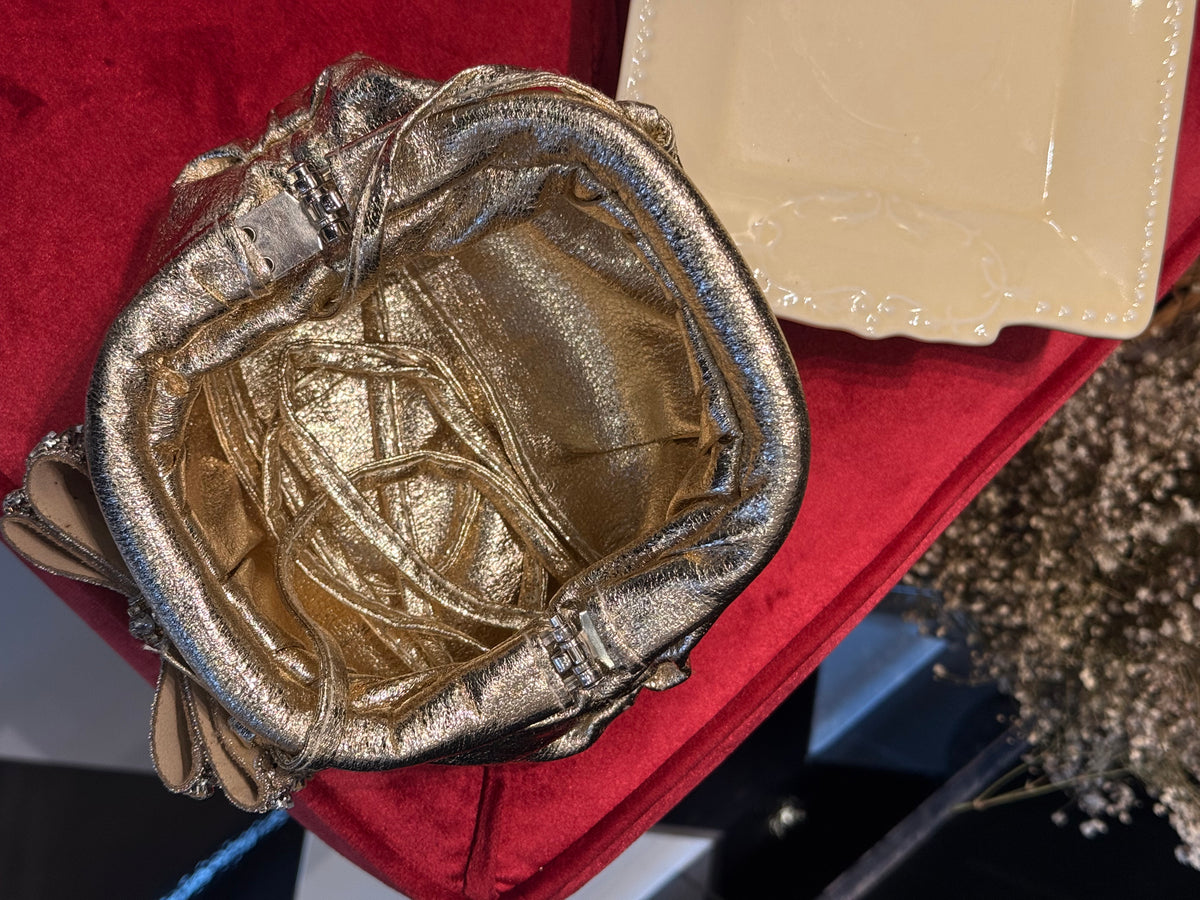 Gold leather clutch with bow embellishments