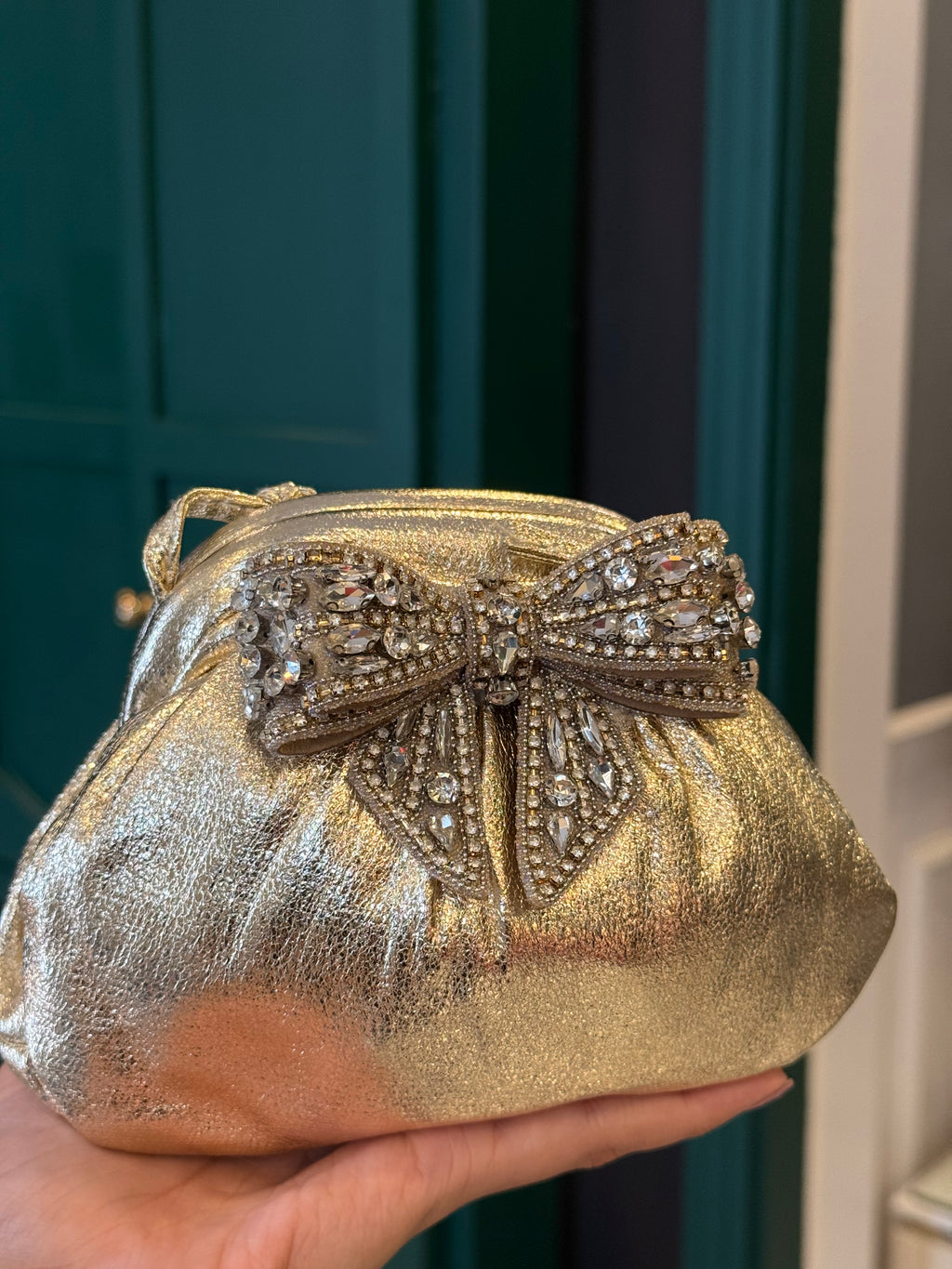 Gold leather clutch with bow embellishments