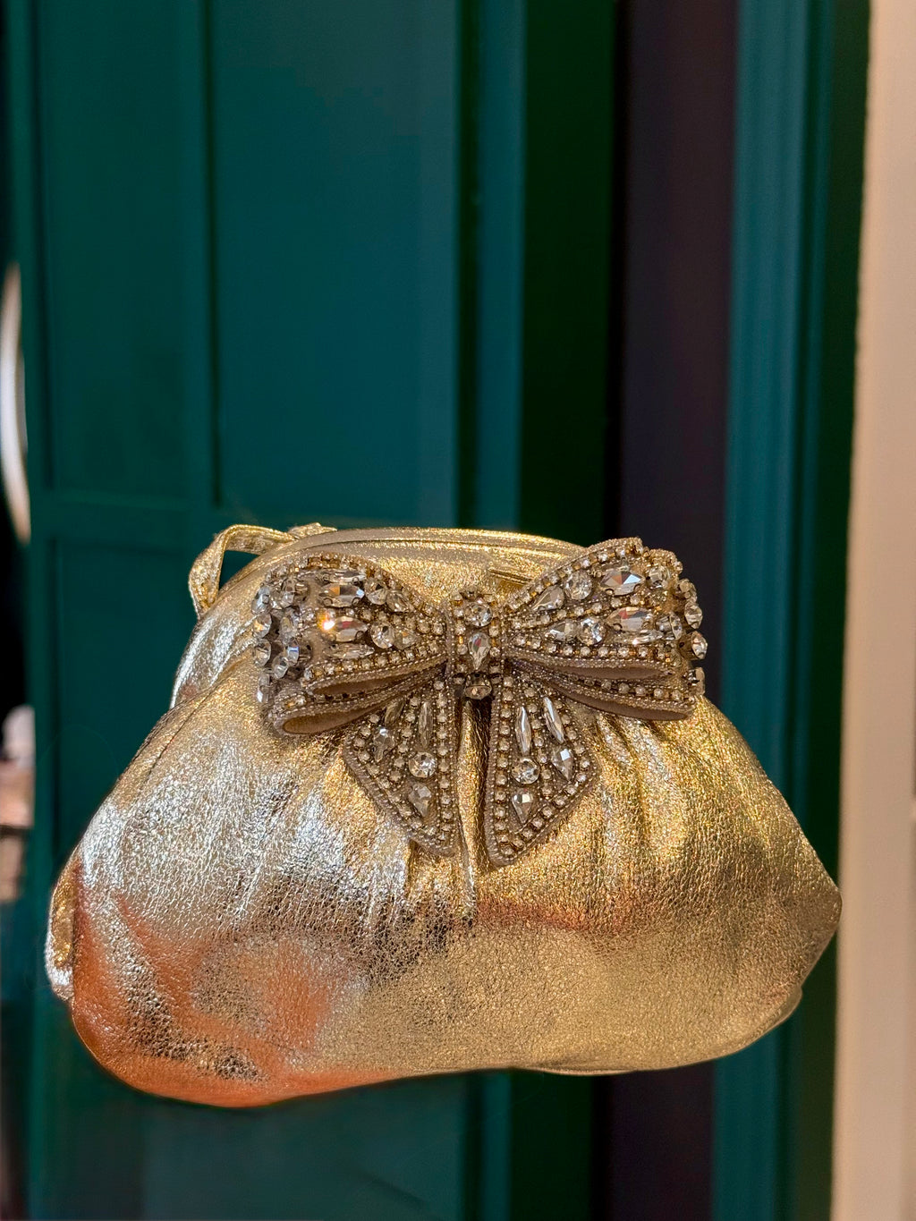 Gold leather clutch with bow embellishments