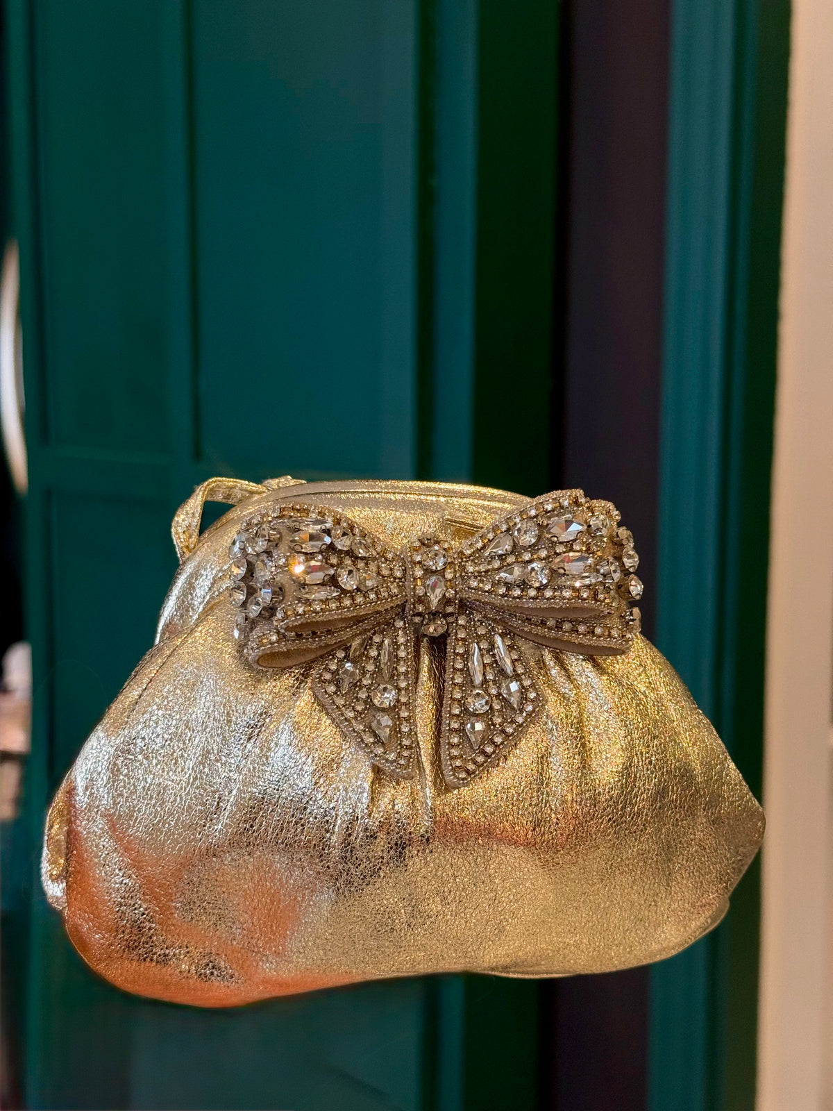 Gold leather clutch with bow embellishments
